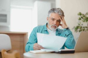 uomo preoccupato legge fogli