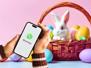 sfondo con uova e coniglietto di Pasqua e logo di WhatsApp su smartphone