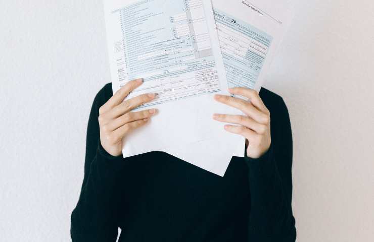 persona copre il volto con modello redditi