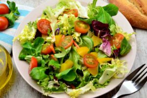 piatto di insalata mista con foglia larga e piccola e pomodorini