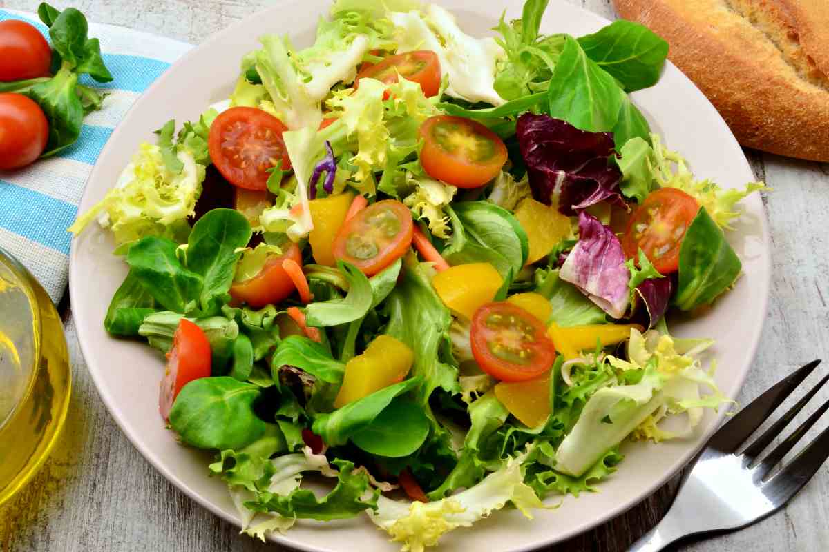 piatto di insalata mista con foglia larga e piccola e pomodorini