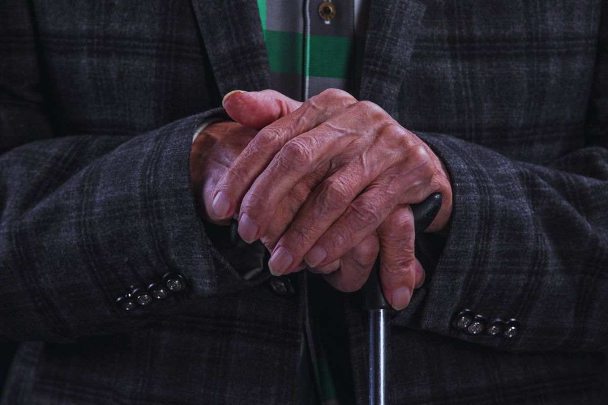 le mani di un anziano e il suo bastone