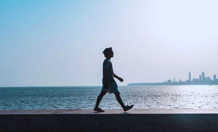 ragazzo cammina sulla spiaggia