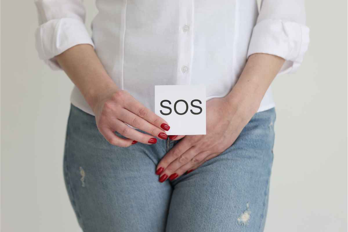 Donna incontinente con in mano in foglietto con scritto SOS