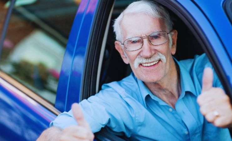 anziano fa il pollice dall'auto