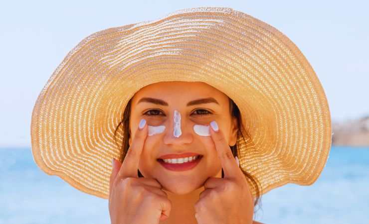 ragazza mette crema sulle guance