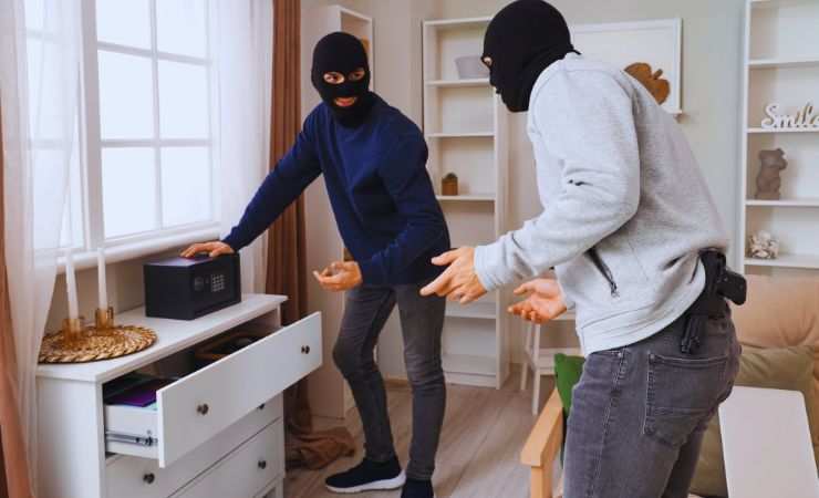 ladri dentro casa che cercano di aprire la cassetta di sicurezza